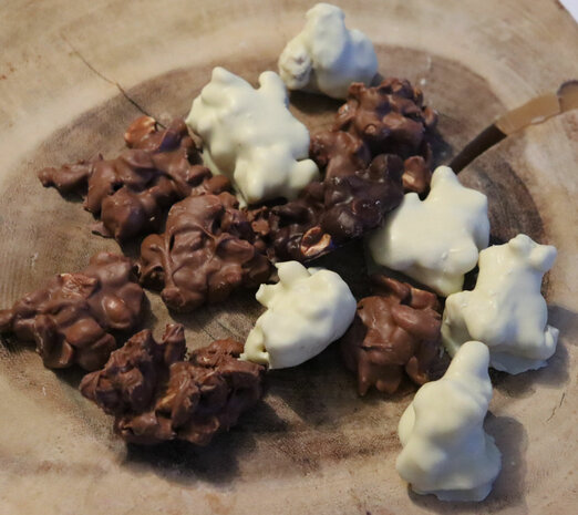 Ambachtelijke pindarotsjes van Belgische melk-, witte en pure chocolade met geroosterde pinda's.